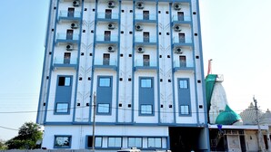 A multi-story building with a modern architectural design, featuring balconies and air conditioning units. - Jainsite (Palitana)