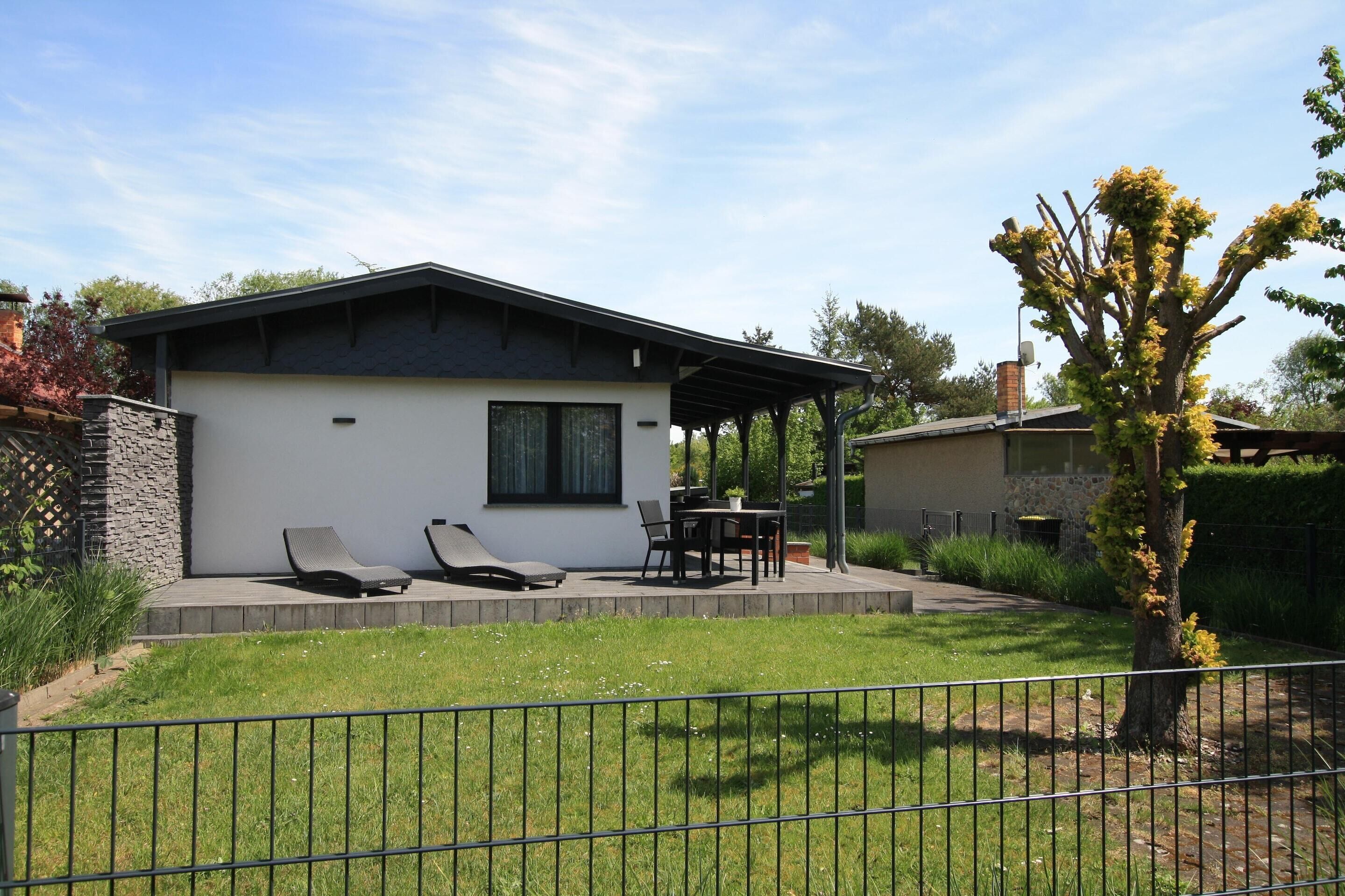 A modern house with a patio, a dining area, and a small garden.