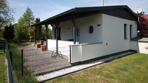 A modern, single-story building with a flat roof, a covered patio area, and a satellite dish. - Ferienhaus Direkt an der Spree (Lübben (Spreewald))