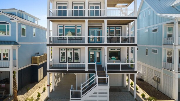 Propiedad frente al mar de varios pisos, con balcones, una galería cubierta y vista al océano.