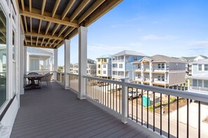 A covered balcony with a view of multi-story residential buildings.
