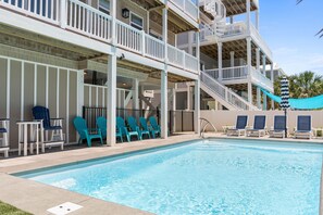 A pool area with blue chairs and a pool.