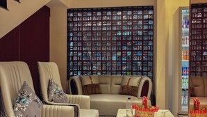 A modern living room with a sofa set, a coffee table, and a decorative window with a patterned view. - Hotel Indigo (Indore)