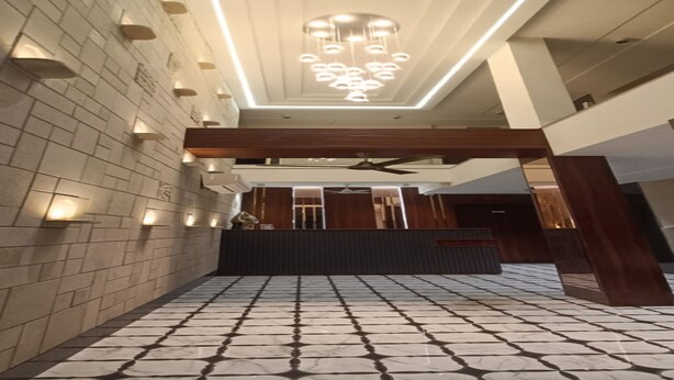 A spacious lobby with a patterned floor, a modern chandelier, and a reception desk. - Hotel Indigo (Indore)