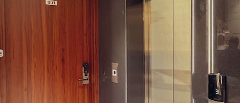 Un ascensor con detalles metálicos y una puerta de madera.