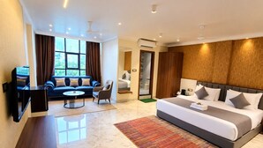 A hotel room with a bed, sofa, TV, and a view of the outdoors. - Hotel Indigo (Indore)