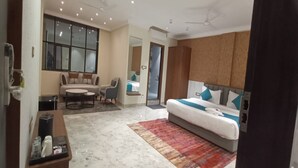 A modern hotel room with a large bed, a sofa, a dining table, and a coffee station. - Hotel Indigo (Indore)