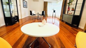 Un comedor moderno con una mesa redonda, sillas y un armario con puertas de vidrio.