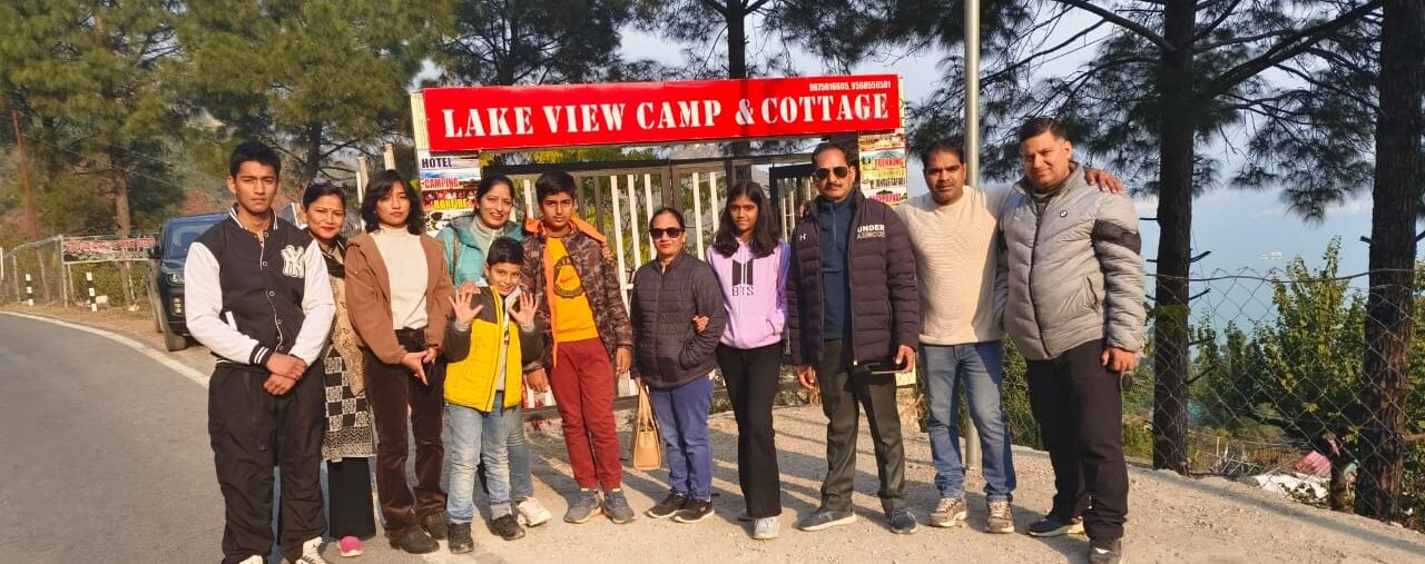 A group of people standing in front of a sign for Lake View Camp & Cottage.