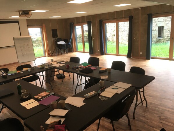 A conference room with a long table, chairs, a whiteboard, and a projector. - Auberge A la Belle Etoile (Mellionnec)
