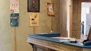 Una taquilla de fusta amb una taula blava, flanquejada per cartells a la paret.