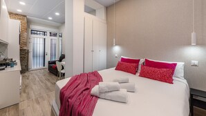 Ein modernes Hotelzimmer mit einem Bett, einem Schreibtisch und einem Stuhl. Es gibt ein Badezimmer mit Spiegel und Dusche.