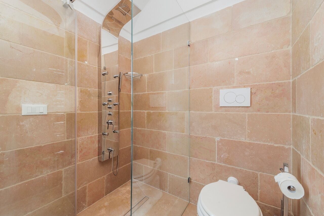 Un baño moderno con ducha de vidrio, inodoro y perchero para toallas.