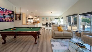 A spacious living room with a pool table, a comfortable sofa, and a dining area. - Mirage Oasis: Pool & Hot Tub [Free Spa Heating + Early Check-In] (Indio)