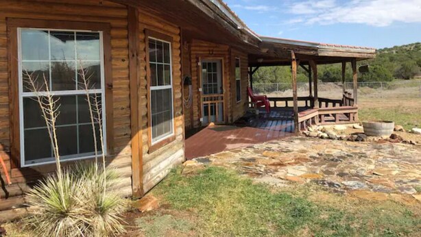 A log cabin with a stone patio and a covered porch. - Cottonwood Creek Cabins - Entire Site (Alpine)