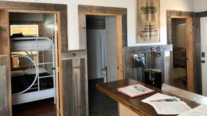 A room with a bunk bed, a wooden desk with papers, and a wall-mounted sign. - Cottonwood Creek Cabins - Entire Site (Alpine)