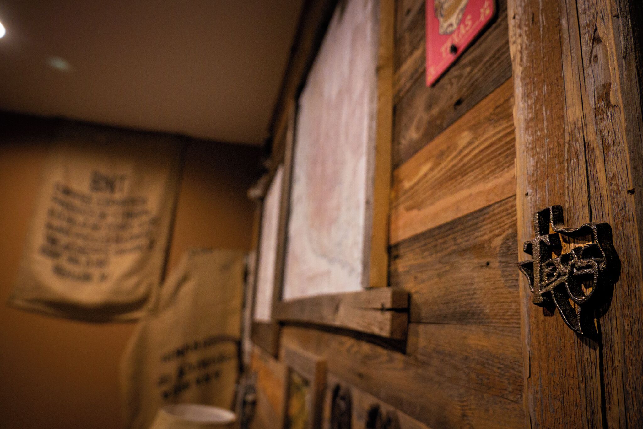 A rustic wooden wall with a metal latch and a red decorative piece.