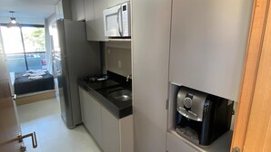 Een moderne keuken met roestvrijstalen apparatuur, een inbouwmagnetron en een koffieapparaat.