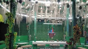 A restaurant with green walls, hanging decorations, and a central table with chairs. - Blue Marine Resort (Saint Martin's Island)
