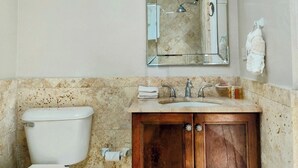 A bathroom with a toilet, sink, and mirror. - ☀️⛱️👙Shore Thing by IRE Vacations- Beachfront 1 Bedroom Condo in Simpson Bay (Simpson Bay)