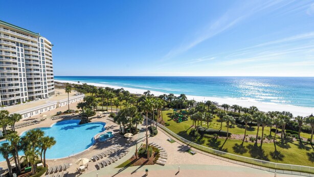 Un resort con una piscina amplia, playa y vista al océano.