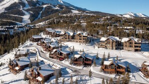 A snow-covered mountain resort with wooden cabins and a ski slope. - Luxurious Moonlight Basin Chalet! Stunning Views with Private Deck with Grill an (Big Sky)