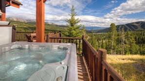 A hot tub on a wooden deck with a mountain view. - Luxurious Moonlight Basin Chalet! Stunning Views with Private Deck with Grill an (Big Sky)