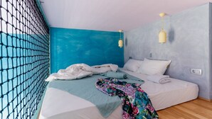 Quarto com cama, janela com mosquiteiro e parede em duas cores.