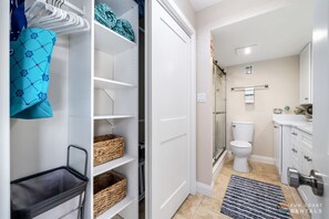 Een moderne badkamer met toilet, douche en wastafel.