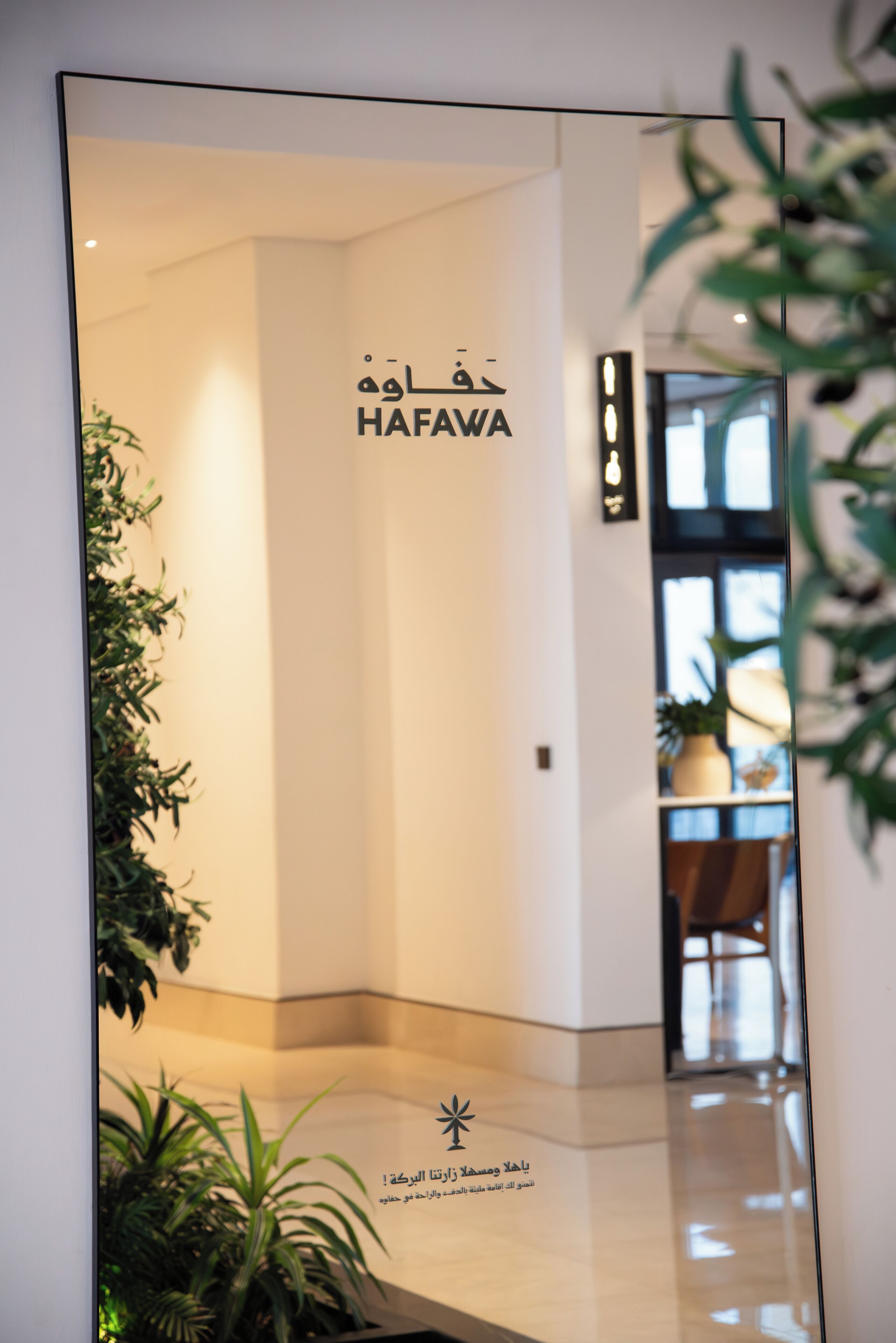 Un interno moderno con un cartello che riporta la scritta “HAFAWA” e caratteri arabi.