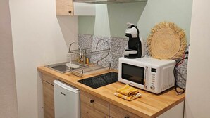 Una cocina funcional con lavavajillas, microondas y cafetera.