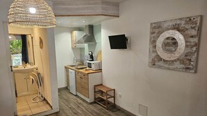 Una cocina funcional con encimera de madera, un lavabo, un microondas y una lámpara colgante.
