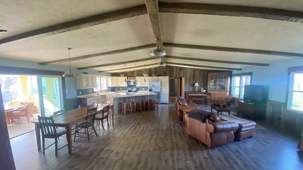 Amplia sala de estar integrada con cocina, mesa de comedor y asientos.