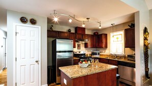 A modern kitchen with wooden cabinets, stainless steel appliances, and a granite countertop. - Feels Like Home - Close to Downtown! (Raleigh)