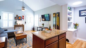 A modern living room with a sofa, coffee table, and a dining area with a table and chairs. - Feels Like Home - Close to Downtown! (Raleigh)