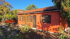 A small, single-story building with a red-tiled roof and a white base. - Casa Donjá (Serro)