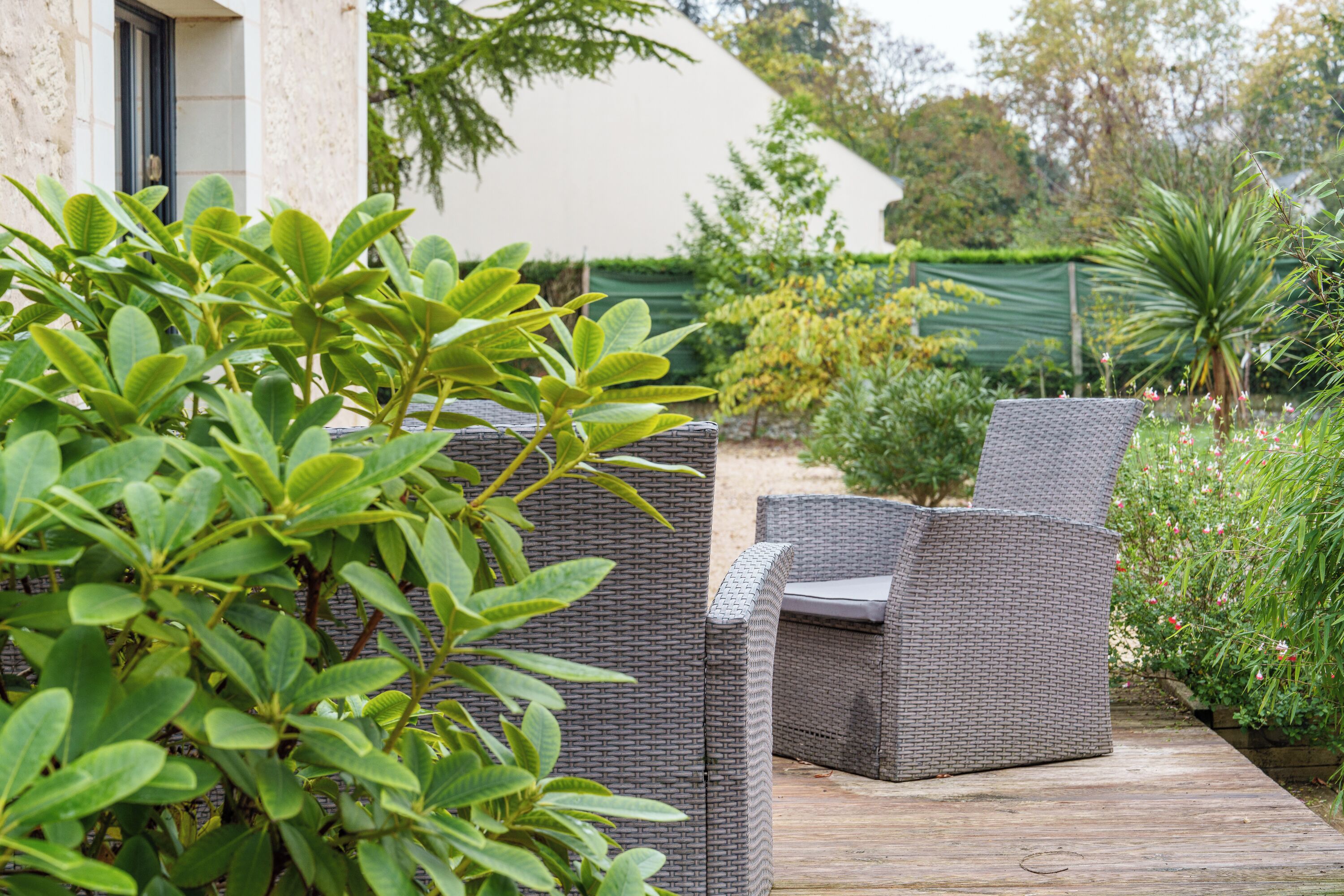 A patio area with wicker furniture and a wooden deck.