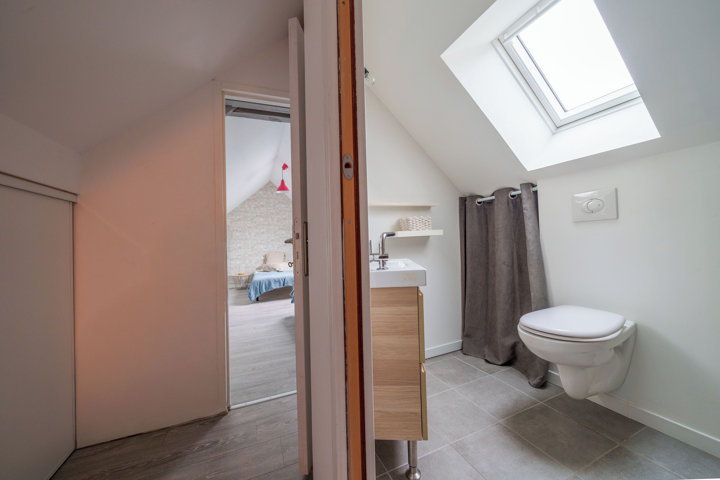 Ein modernes Badezimmer mit Oberlicht, Toilette und Waschbecken.
