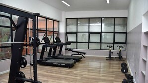 Una palestra con tapis roulant, macchinari per esercizi e pesi liberi.