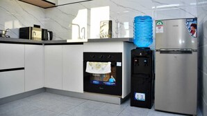 Una cucina moderna con forno integrato, frigorifero e distributore d'acqua.