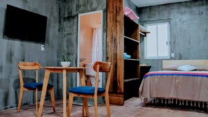 A room with a bed, a desk with a chair, a TV mounted on the wall, and a wooden bookshelf. - Quiet stay near Zócalo · Wi-Fi · Terrace · Walkable · For 2 guest (Oaxaca de Juárez)