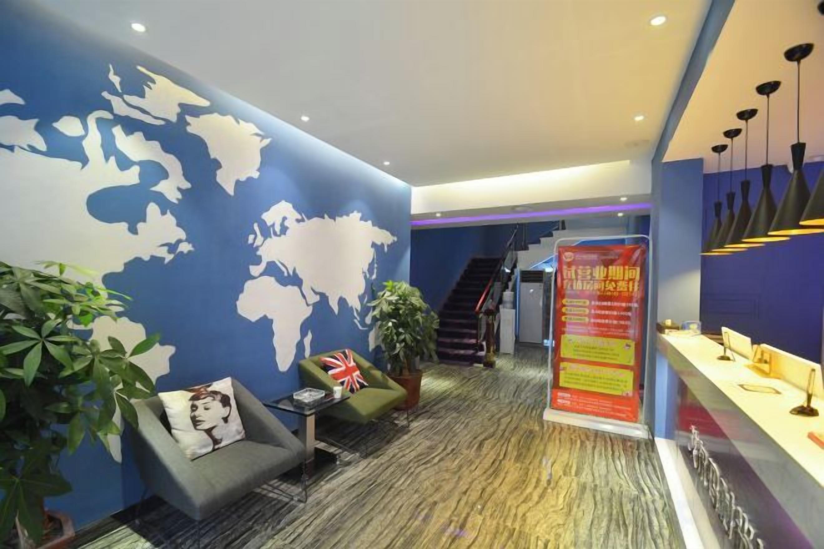 A lobby with a world map on the wall, a reception desk, and a staircase.