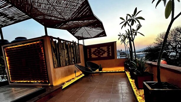 A rooftop terrace with tiled flooring, a seating area with chairs, a decorative wall, and potted plants. - Quiet stay near Zócalo · Wi-Fi · Terrace · Walkable · For 2 guest (Oaxaca de Juárez)