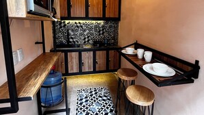 A compact kitchen with wooden cabinets, a patterned backsplash, and a small dining area with stools. - Quiet stay near Zócalo · Wi-Fi · Terrace · Walkable · For 2 guest (Oaxaca de Juárez)