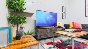 A living room with a television, sofa, coffee table, and decorative items.