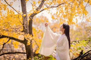 A person standing in a natural setting with trees and foliage. - Wang Xing Hotel (Nanxiong)