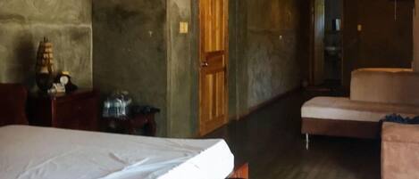 A room with a bed, a chair, and a small table.