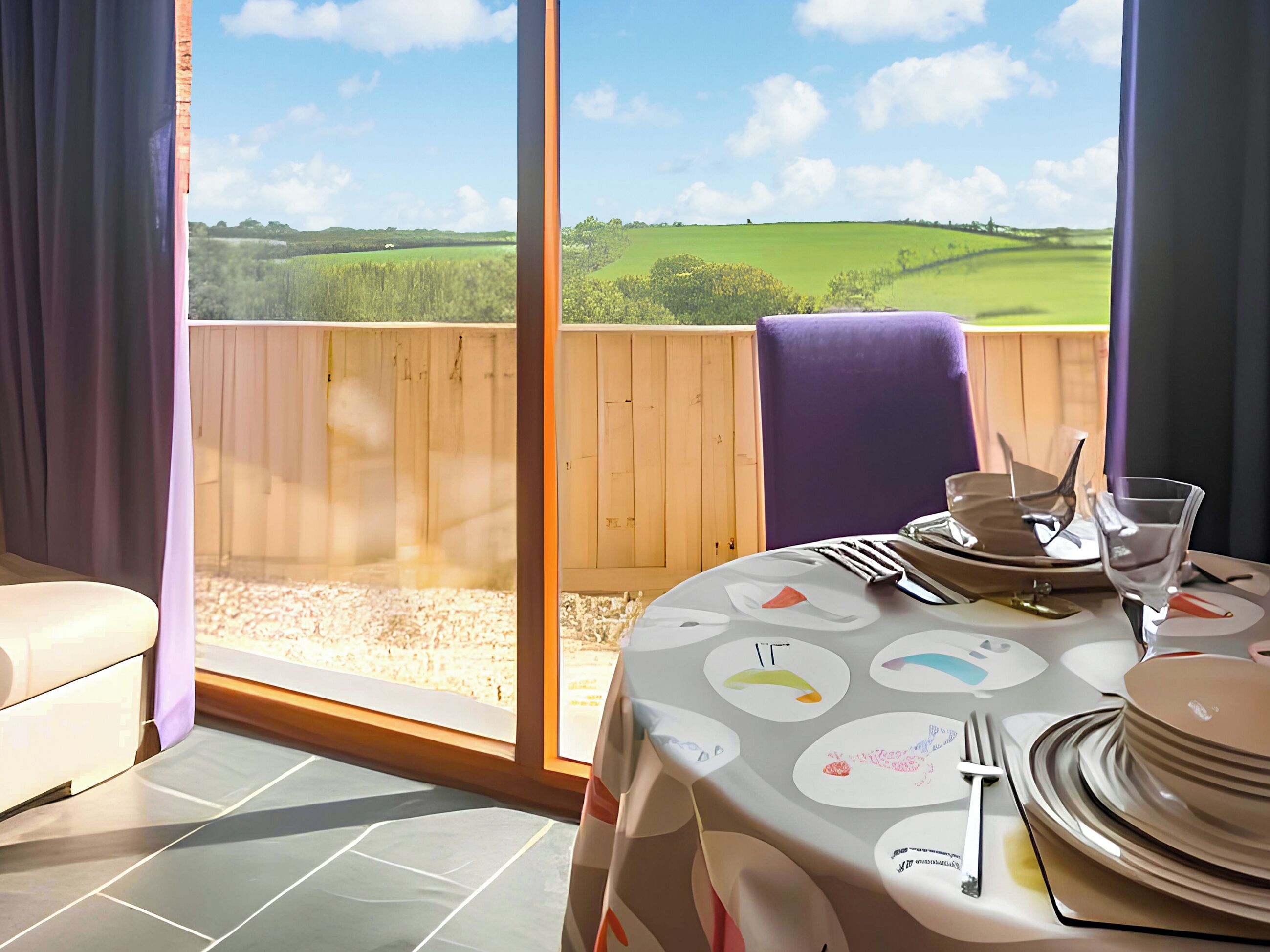 Un coin repas avec une table dressée pour deux personnes, une chaise et une vue sur un paysage verdoyant, visible à travers de grandes fenêtres.