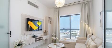 Departamento estándar, vista a la ciudad | Área de sala de estar | Smart TV de 55 pulgadas con canales por cable