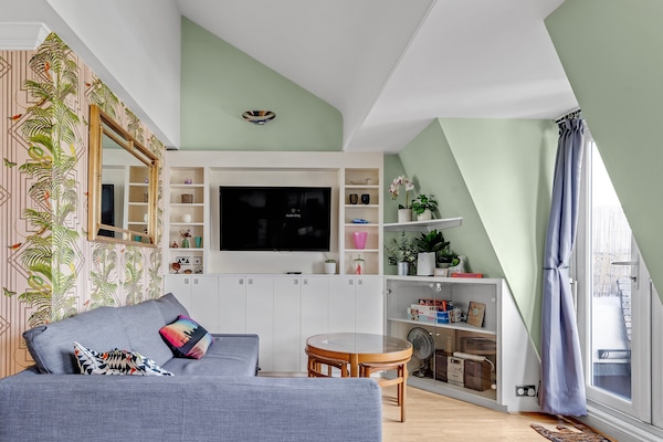 Open plan living room and kitchen with French doors opening onto the balcony.